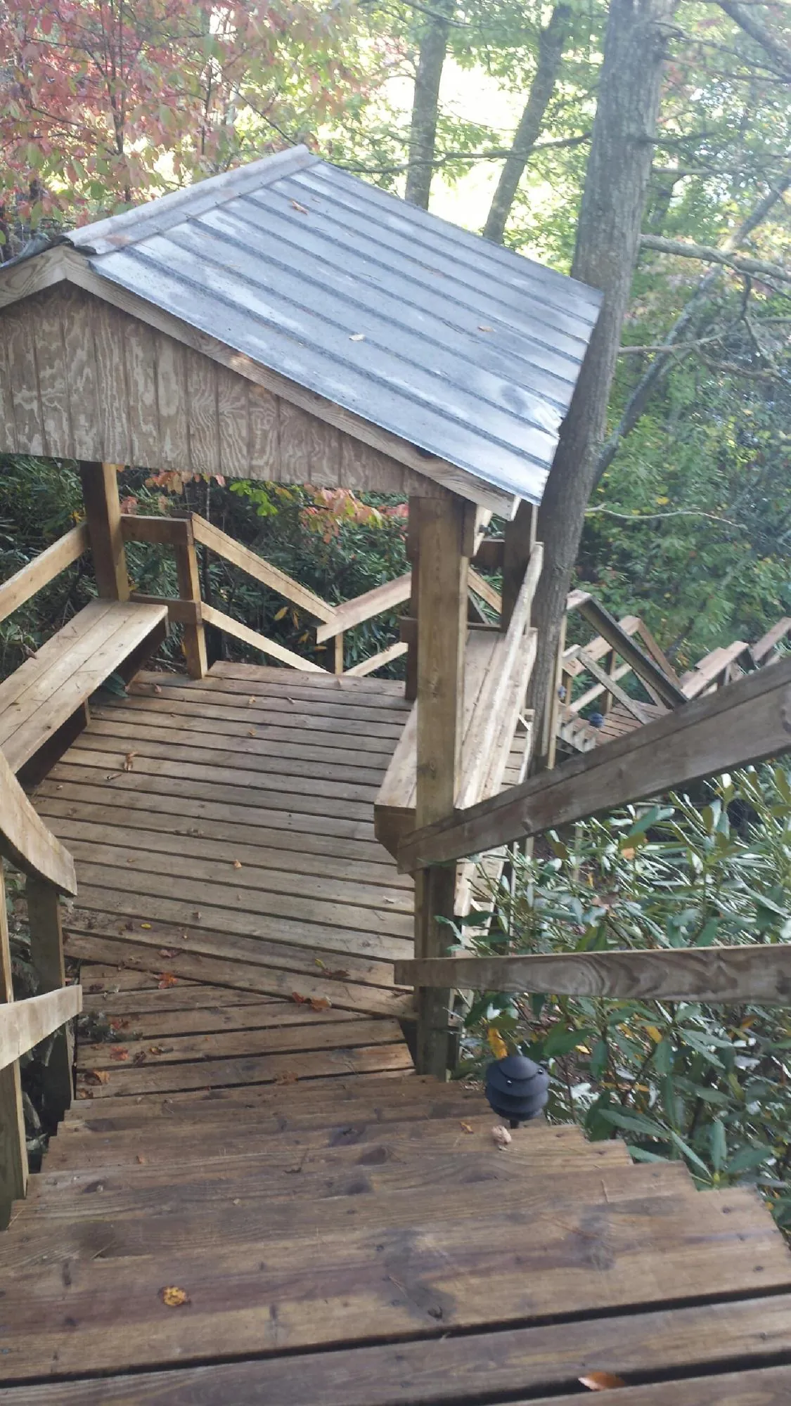 Metal roofed shelter over wooden steps on a wooded walkway — Skylight Repair & Installation work by our crew in Church View