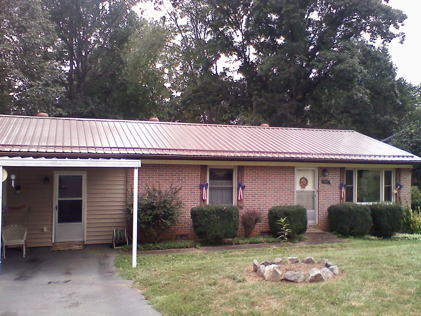 Bronze metal roof and carport on a brick ranch home — Roof Repair work by our crew in Church View